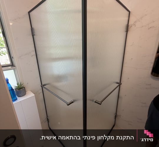 מקלחון פינתי עם דלתות זכוכית מחוסמת